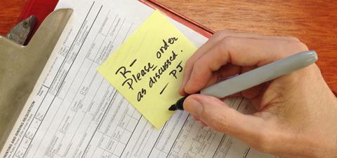 Person writing on post-it