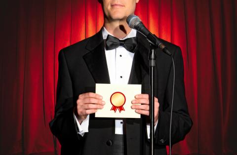 Man holding an awards envelope