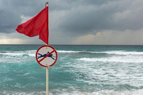 Red flag on stormy beach