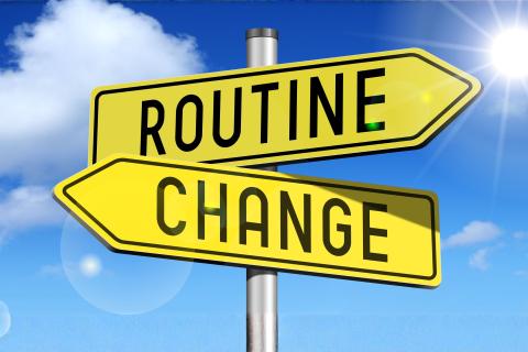 Two signs pointing in opposite directions: routine and change
